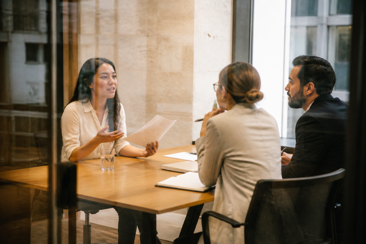 Candidate speaking with the Growth Academy hiring team during an interview, resume in hand